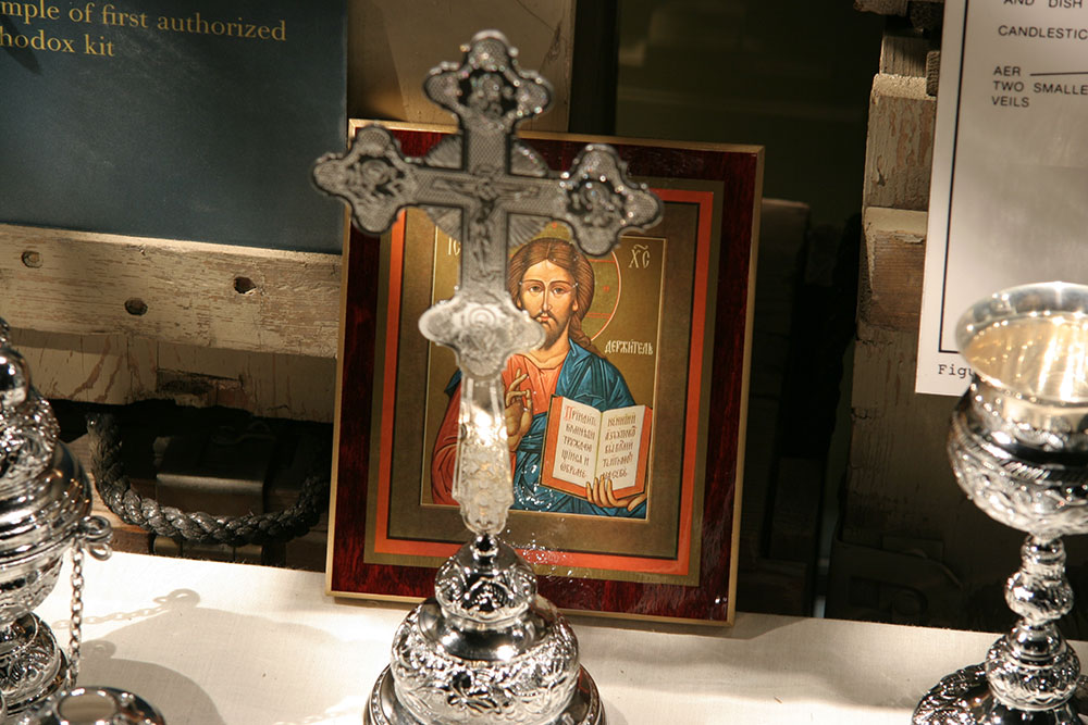 A cross and portrait of Jesus Christ as part a of a museum exhibit inside the US Army Chaplain Corps Museum.